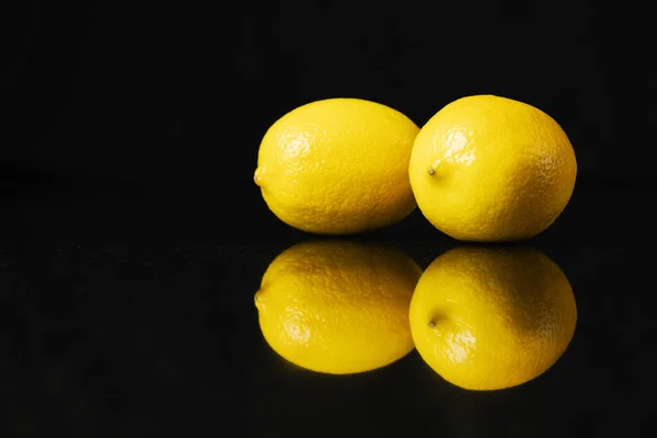 Dos Limones Sobre Una Superficie Negra Reflejada — Foto de Stock