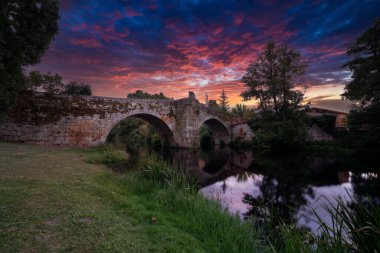 Roman bridge of allariz Orense sunset clipart