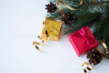 Noel hediyeleri ve ladin dalları beyaz ahşap bir arka planda