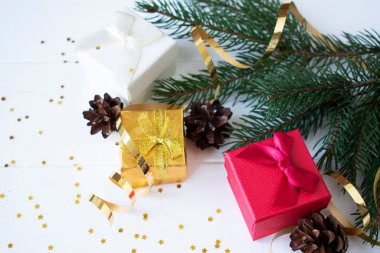 Noel hediyeleri ve ladin dalları beyaz ahşap bir arka planda