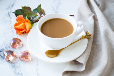 Beyaz bir fincanda Americano ve masanın üstünde süslemeli kalpler.