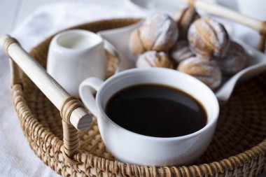 Kahvaltıda hasır tepside sütlü ve şekerli bir fincan sade kahve.