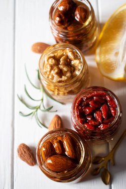 farklı fındıklar kavanozlarda bal içinde ahşap masada