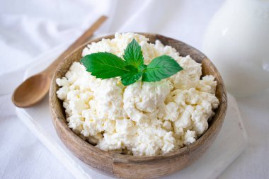 Kahvaltı için beyaz bir masada naneli süzme peynir.