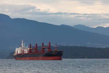 Dağların arkasında eski büyük bir kargo gemisi. Petrol tankeri denize demir atmış. Vancouver BC 'de. Metin, seçici odak, seyahat fotoğrafı, konsept fotoğraf ticareti için alanı kopyala