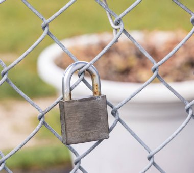 Asma kilit ızgaraları. Metal çit ve paslı asma kilit. Sokak manzarası, bulanık arka plan, hiç kimse, seçici odak