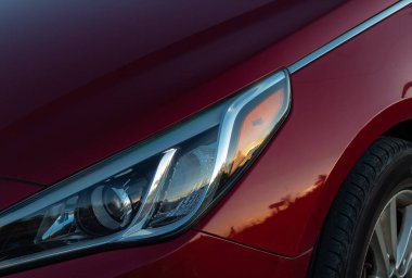Kırmızı spor araba farlarının yakın görüntüsü. Bir arabanın far ışığı, LED farlarından birinin detaylarını kapat modern araba..