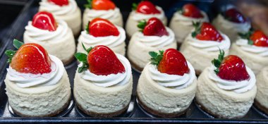 Pasta dükkan vitrininde ya da kafede sergileniyor. Vancouver BC 'deki Granville pazarındaki şekerleme tezgahında sergilenen taze hamur işleri. Bulanık arkaplan, seçici odak, hiç kimse.