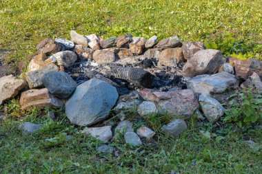 Kamptaki yeşil çimlerde yandıktan sonra kamp ateşi. Seçici odak, hiç kimse, seyahat fotoğrafı