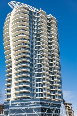 Modern, yüksek katlı bir apartmanın ön yüzü. Yüksek Binalı Konut Binasının Soyut Mimari Detayları. Sokak fotoğrafı, hiç kimse, seçici odak