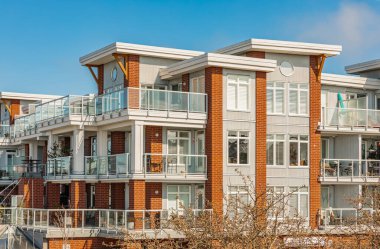 BC, Kanada 'da güneşli bir günde yepyeni bir apartman. Modern apartman binasının mimari detayları