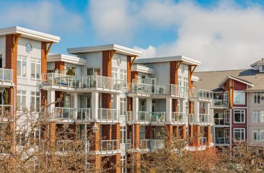 BC, Kanada 'da güneşli bir günde yepyeni bir apartman. Modern apartman binasının mimari detayları