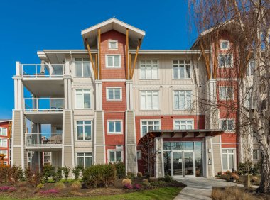 BC, Kanada 'da güneşli bir günde yepyeni bir apartman. Modern apartman binasının mimari detayları