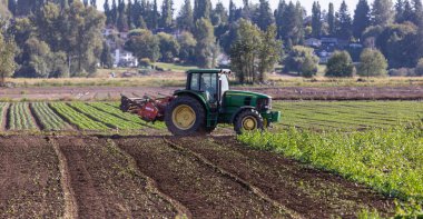 Traktör bahar ya da sonbahar mevsiminde tarlaları sürüyor. Sokak fotoğrafı, konsept fotoğraf tarımı, seçici odak noktası MÖ 1.2021-Vancouver, Kanada.