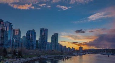 Vancouver şehir merkezindeki modern binaların gece manzarası. Vancouver Canada 'da uzun süre deniz kenarında görülmüş. Gökdelenlerle dolu renkli bir şehir gecesi. Sokak fotoğrafı, seçici odak noktası, gece fotoğrafı 11 Nisan 2022