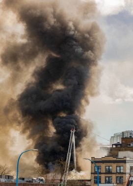 Şehirdeki bir yangından çıkan duman görüntüleri. Büyük bir yangın, yangının etkileri. Şehrin üzerindeki yangından çıkan duman. Sokak fotoğrafı, seçici odak, hiç kimse