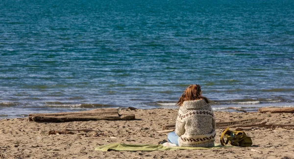 Femme assise seule sur le sable et jouissant du soleil — Photo
