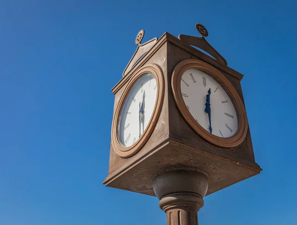 Straßenuhr. Vintage-Uhr auf einer Stange isoliert auf einem blauen Himmel — Stockfoto
