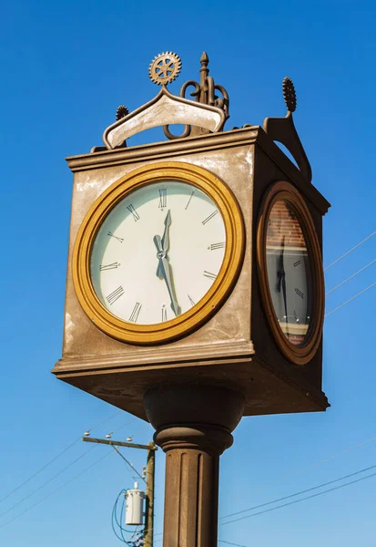 Straßenuhr. Vintage-Uhr auf einer Stange isoliert auf einem blauen Himmel — Stockfoto