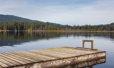 Bulutlu bir sabahta dağ manzaralı göldeki ahşap iskele manzarası. Seyahat fotoğrafı, hiç kimse, seçici odak.