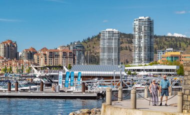 Yazın Kelowna Skyline ve Okanagan Lake British Columbia Canada manzarası. Güneşli yaz gününde şehir manzarası. İnsanlar 7 Haziran 2022 tarihli metin için Kelowna Tahta Kaldırımlı Seyahat fotoğrafı, metin boşluğu üzerinde yürüyorlar