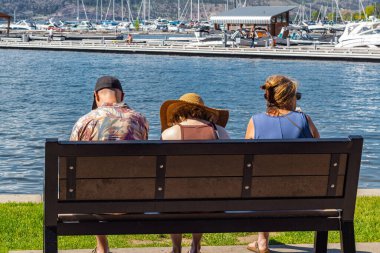 İnsanlar yaz parkında güneş ışığının tadını çıkarıyorlar. Açık hava aktivitesi. Okanagan Gölü, BC, Kanada-7 Haziran 2022 tarihli seyahat fotoğrafı, seçici odak noktası