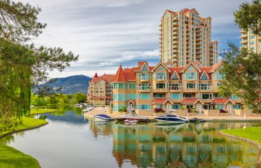 Kelowna Skyline yazın Okanagan Gölü 'nden bulutlu bir günde Kanada' da. Resort Waterfront Parkı ve şehir merkezindeki yerleşim alanı. Şehir simgesi, yaz tatili - 7 Haziran 2022