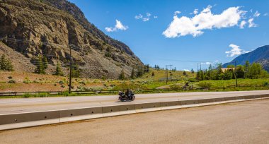 Dağdaki otoyol. Otobanda, dağ sırasındaki arka planda motosiklet çok hızlı gidiyor. Bisiklet yolda 6 Haziran 2022-Hedley BC, Kanada 'da. Seyahat fotoğrafı.