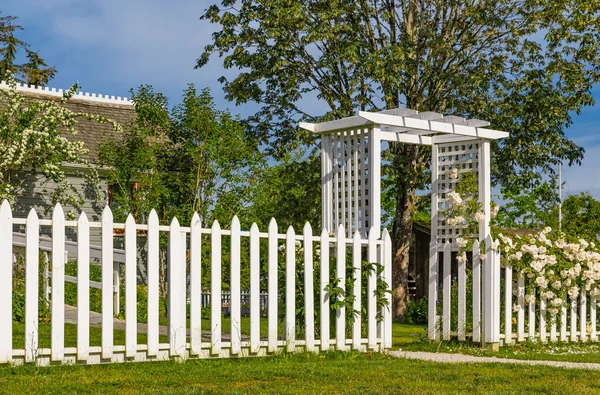 Garden gate with White Picket Fence and white roses. Romantic photo for wedding background. Nobody, selective focus