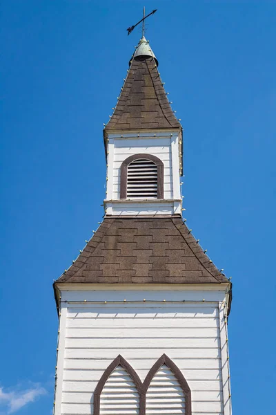 Exterior of a Little White Country Church on a Sunny Day and blue sky at the background. Beautiful traditional church in rural Canada-June 30,2022-Langley BC-Nobody, travel photo, copy space for text