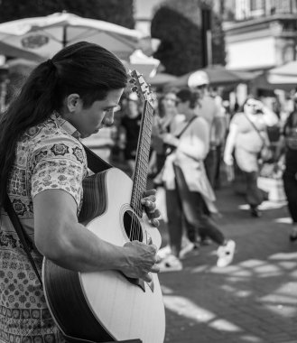 Şehir caddesinde romantik bir adam gitar çalıyor. Bir sokak müzisyeni dışarıda çalıyor. Aşk, romantizm, aşıklar, serenat, romantizm, seyahat fotoğrafı - 19 Temmuz 2022 - MÖ Kanada