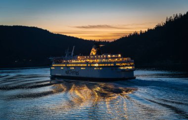 BC Ferries yolcu gemisi Spirit of British Columbia gün batımında denizde olacak. BC Feribotları güzel Pasifik okyanusu ve dağ arka planında. Seyahat fotoğrafı - 21 Temmuz 2022-Kanada