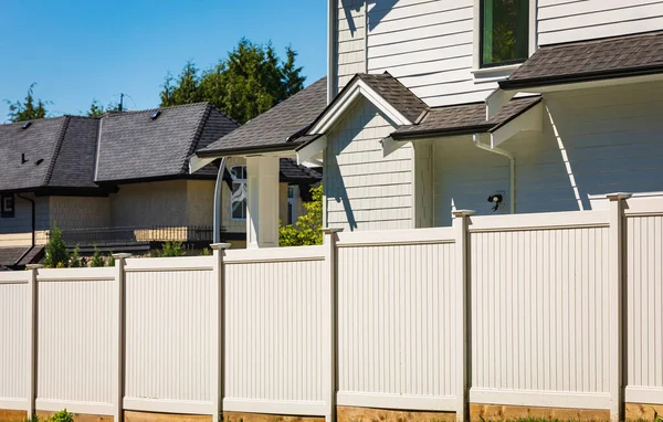 Nice wooden fence around house. Wooden fence with green lawn. Street photo, nobody, selective focus