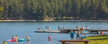 People enjoying summer time at the popular Cultus Lake Beach in British Columbia, Canada. Summer holidays vacation and activity concept, travel photo-July 26,2022