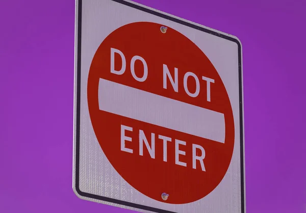 Do not enter sign on purple color background. Do not enter sign in a city. Nobody