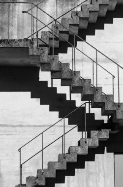 Abstract architecture background, square concrete stairway perspective, stairwell, black and white photo. Minimalism architecture. Modern architecture with distinguishing shades of black and white.
