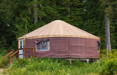 Urta nomadic house in the mountains. Yurt traditional nomadic house on the green grass in a forest. Nobody, travel photo.