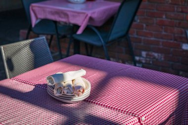 Background with table and tablecloth in outdoor restaurant. Table setting in cafe. Empty table with red checked tablecloth. Nobody, copy space for text