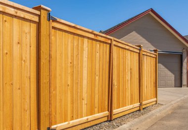 Nice new wooden fence around house. Wooden fence with lawn. Street photo, nobody, selective focus