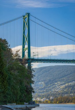 Lions Gate Bridge in summer day, Vancouver, BC, Canada. View of Lions Gate Bridge from Stanley Park. Built in the 1930s, Vancouver's Lions Gate Bridge spans across Burrard Inlet to the Northshore