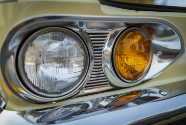 Vintage Car Front detayı. Klasik araba farları, yakın plan. Sarı klasik arabanın farları. Sergi. Hiç kimse, sokak fotoğrafı, seçici odak, bulanık