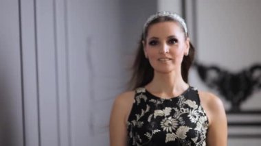 Siyah elbiseli güzel bir kadın pencerenin yanındaki aynada kendine hayran. Siyah elbiseli kadın. Siyahlı kadın stüdyodaki fotoğrafçıya poz veriyor.. 