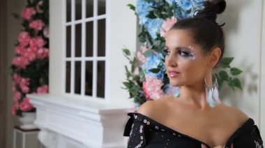 Siyah elbiseli güzel bir kadın pencerenin yanındaki aynada kendine hayran. Siyah elbiseli kadın. Siyahlı kadın stüdyodaki fotoğrafçıya poz veriyor.. 