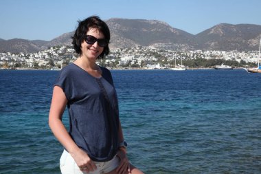 Güzel kız deniz arka plan üzerinde kamera için poz. Model yaz gün sahilde poz.