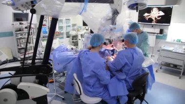 KYIV, UKRAINE - 25 Mayıs 2022: Nörocerrah ventrikül-peritoneal shunting yapar. Şant tıbbi kondüktörü. Ventrikül-periton ameliyatı. Şant rehberi ile yan yana. Editör görüntüsü.