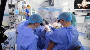 KYIV, UKRAINE - 25 Mayıs 2022: Nörocerrah ventrikül-peritoneal shunting yapar. Şant tıbbi kondüktörü. Ventrikül-periton ameliyatı. Şant rehberi ile yan yana. Editör görüntüsü.