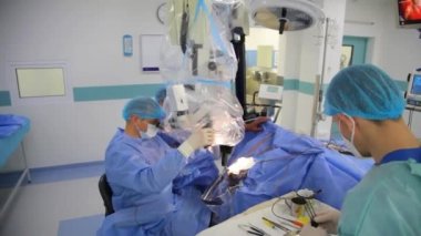 KYIV, UKRAINE - 25 Mayıs 2022: Nörocerrah ventrikül-peritoneal shunting yapar. Şant tıbbi kondüktörü. Ventrikül-periton ameliyatı. Şant rehberi ile yan yana. Editör görüntüsü.