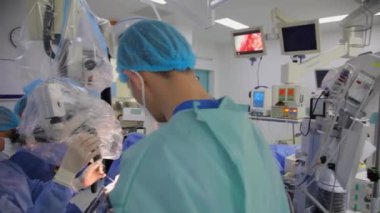 KYIV, UKRAINE - 25 Mayıs 2022: Nörocerrah ventrikül-peritoneal shunting yapar. Şant tıbbi kondüktörü. Ventrikül-periton ameliyatı. Şant rehberi ile yan yana. Editör görüntüsü.