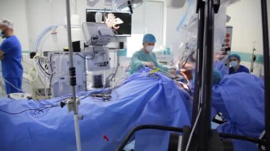 KYIV, UKRAINE - 25 Mayıs 2022: Nörocerrah ventrikül-peritoneal shunting yapar. Şant tıbbi kondüktörü. Ventrikül-periton ameliyatı. Şant rehberi ile yan yana. Editör görüntüsü.