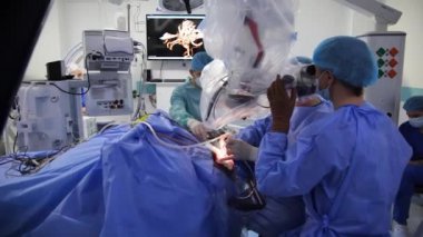 KYIV, UKRAINE - 25 Mayıs 2022: Nörocerrah ventrikül-peritoneal shunting yapar. Şant tıbbi kondüktörü. Ventrikül-periton ameliyatı. Şant rehberi ile yan yana. Editör görüntüsü.